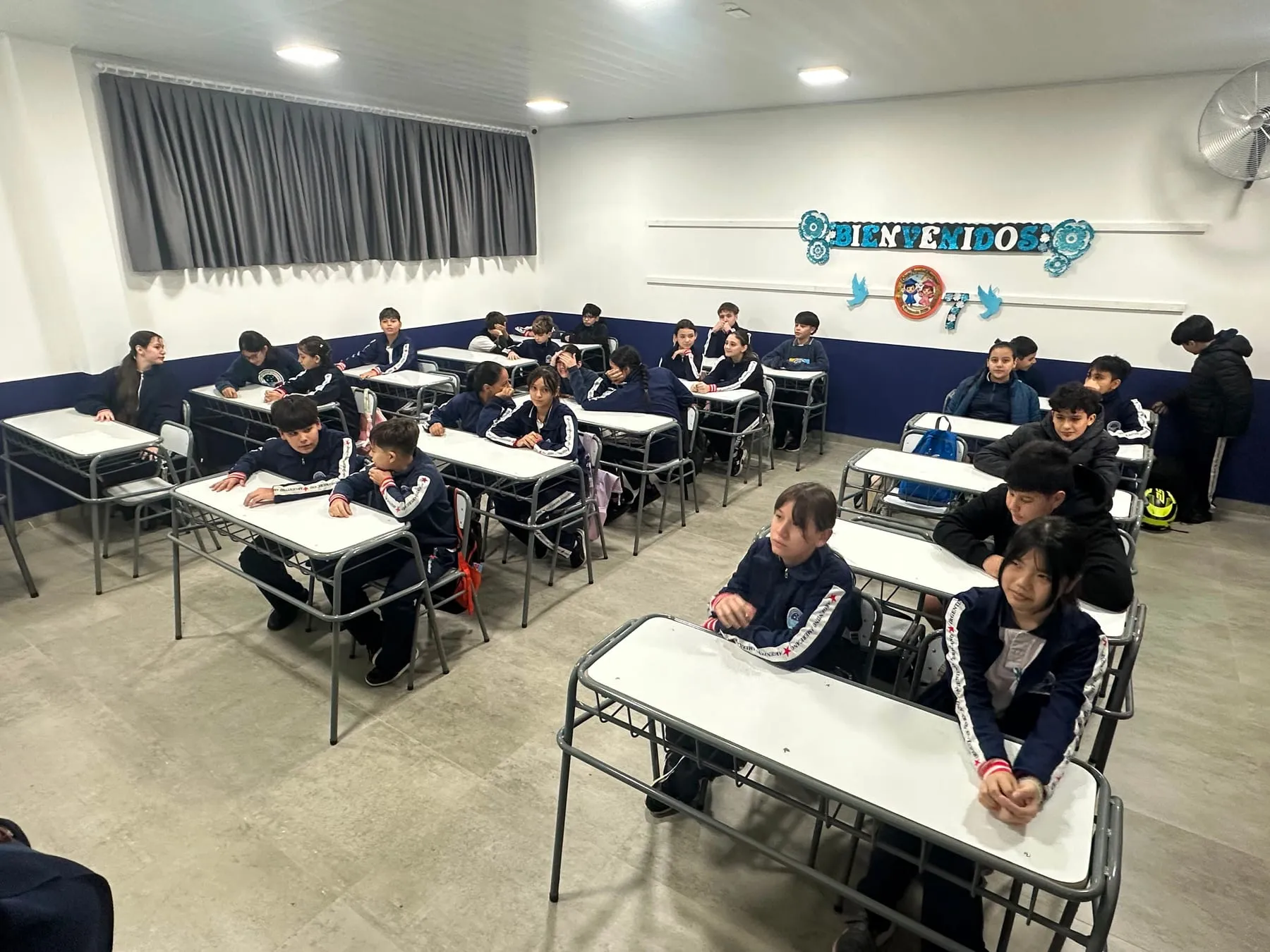 Alumnos de séptimo grado en un aula del Nivel Primario, bajo el cartel de bienvenida